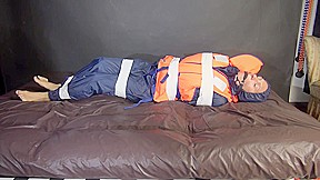 Sexy Sandra Being Tied And Gagged With Tape On A Bed Wearing Blue Rainwear And A Lifevest (Video)