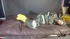 Watching Sexy Pia Being Tied And Gagged With Tape On A Bed Wearing A Sexy Camouflage Shiny Nylon Rainpants And A Rainjacket As Well As Yellow Rubber Boots (Video)