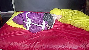 Watching Sexy Sonnja Wearing A Black Shiny Nylon Down Skirt And A Purple Downjacket Being Tied And Gagged With Ropes And A Ballgag On A Bed (Video)